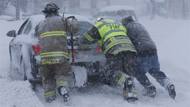 Hasii pomhaj vyprostit auto, kter uvzlo po pvalech snhu na silnici ve stt New York, 18. 11. 2014