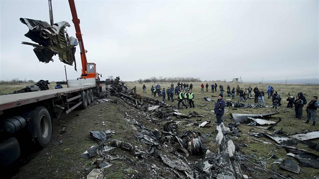 Trosky Boeingu 777 malajsijských aerolinek na jeřábu. V neděli začalo odklízení trosek letadla zříceného na Ukrajině. (16. listopadu 2014)