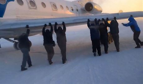 Pasaéi aerolinek UTair roztlaují letadlo na letiti v sibiské Igarce.