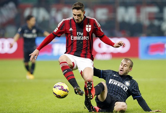 JISKENÍ V DERBY. De Sciglia z AC Milán ve skluzu atakuje Palacio z Interu.