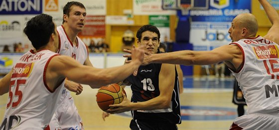 Dínský basketbalista Filip Kroutil (v tmavém) proniká nymburskou obranou...