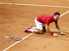 RADOST NA KOLENOU. Roger Federer získal rozhodující bod a poprvé v kariée si...
