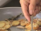 Pi opékání se snate stále rovnat brambory, aby byly na ploe.