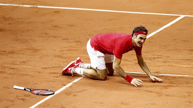 RADOST NA KOLENOU. Roger Federer zskal rozhodujc bod a poprv v karie si uv triumf v Davis Cupu.