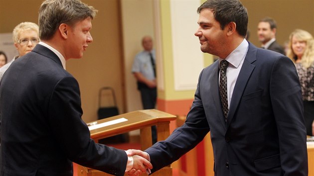 Zastupitel Karel Bezina (vpravo) skld slib do rukou odstupujcho primtora Tome Hudeka (26.11.2014)