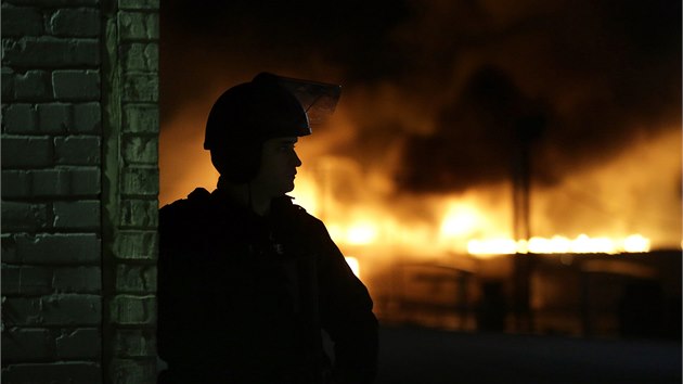 Proti rozzuenmu davu nasadila policie slzn plyn. Demonstranti zapaluj ve Fergusonu budovy i destky aut (25. listopadu 2014)