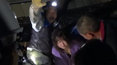 Záchranái vytahují enu z domu pokozeného zemtesením. (23. listopadu 2014)