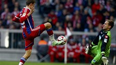 Thomas Müller z Bayernu Mnichov zkouí pekonat gólmana Hoffenheimu Olivera...