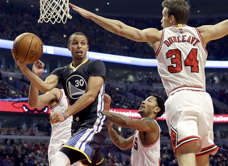Stephen Curry z Golden State pihrává mezi trojicí hrá Chicaga. Zleva: Joakim...