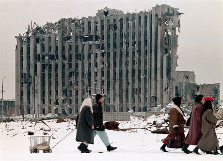 10 Chechen women and men pass in February 1996 by the destroyed presidential...