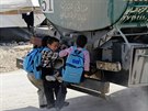 Syrské dti se vezou na cistern vody v uprchlickém táboe Zátarí v Jordánsku...
