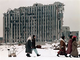 10 Chechen women and men pass in February 1996 by the destroyed presidential...