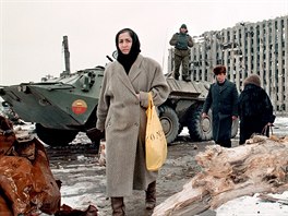 1 Chechen women and men pass in February 1996 by a Russian Army armoured...