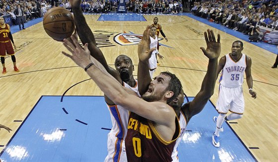 Kevin Love (v rudém dresu) z Clevelandu se snaí prosadit pod koem Oklahomy...