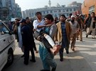 Pákistánec odnáí mladíka, který utrpl zranní pi útoku Talibanu na kolu v...