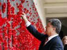 Ukrajinský prezident Petro Poroenko umisuje kvt vlího máku pi návtv...