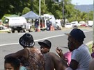Obyvatelé pedmstí Manoora australského msta Cairns sledují policii kousek od...