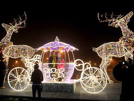 People have photos taken in a Christmas decoration on a street in Warsaw,...