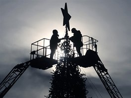 Content: Workers decorate a Christmas tree at Lenin's Square as a plane...