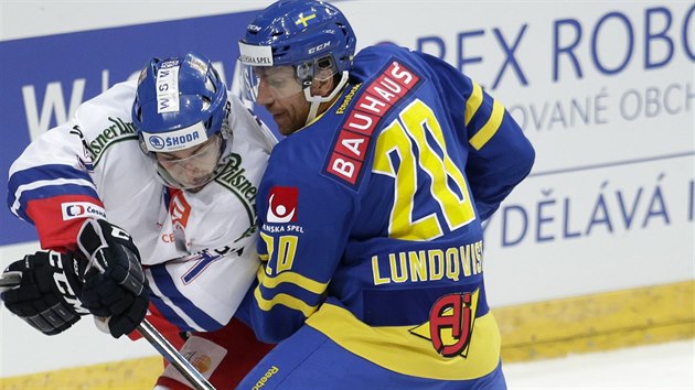 Český hokejista Jakub Valský (vlevo) bojuje o puk s Joelem Lundqvistem z týmu Švédska.