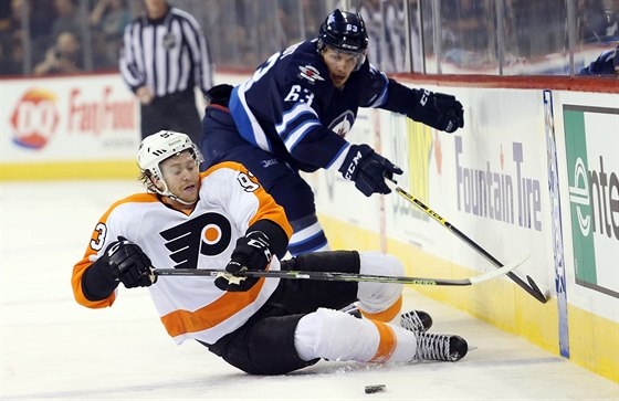 Jakub Voráek z Philadelphie padá po zákroku Bena Chiarota z Winnipegu.