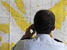 Dstojník u mapy v krizovém centru zízeném na letiti v indonéské Surabáje.