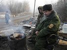 Prorutí ozbrojenci se ohívají na kontrolním stanoviti u msta Makijivka,...