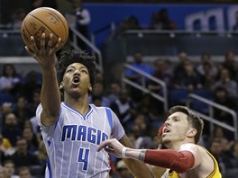 Elfrid Payton (vlevo) z Orlanda zakončuje na koš Clevelandu kolem Mika Millera.
