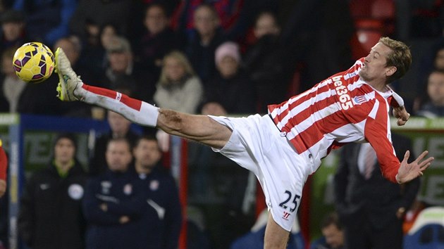 Peter Crouch ze Stoke City se natahuje po mi.