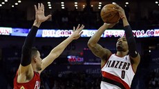 Damian Lillard z Portlandu stílí na ko New Orleans ptes ruku Austina Riverse.