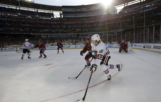 Patrick Kane z Chicaga s pukem, sleduje ho washingtonský obránce Matt Niskanen.