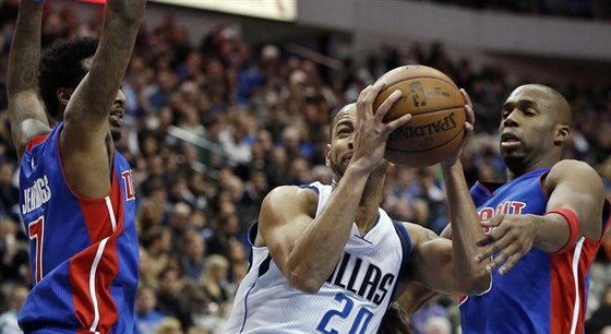 Devin Harris (uprosted) z Dallasu útoí mezi detroitskými basketbalisty...