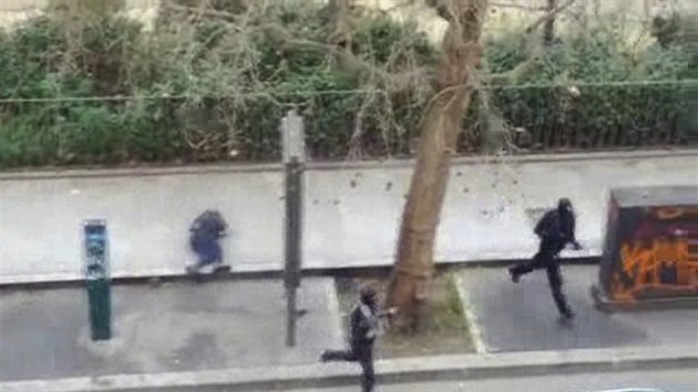 Maskovan tonci prchaj pot, co ped redakc asopisu Charlie Hebdo zastelili policistu. Snmek z amatrskho videa. (7. ledna 2015)