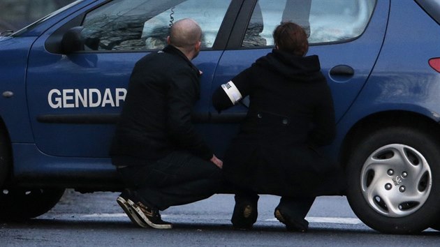 Policisté se kryjí při zásahu speciálních složek v tiskárně na okraji města Dammartin-en-Goële, severovýchodně od Paříže (9. ledna 2015).