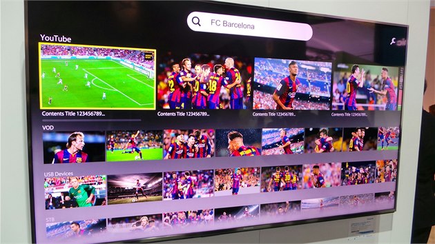 Standardem nejen u Panasonicu je vyhledávání hlasem. Příklad na obrazovce: na dotaz FC Barcelona vyskočí všechny relevantní nabídky televizních kanálů, videa z nainstalovaných služeb (VOD), připojených zařízení (USB disk), atd.