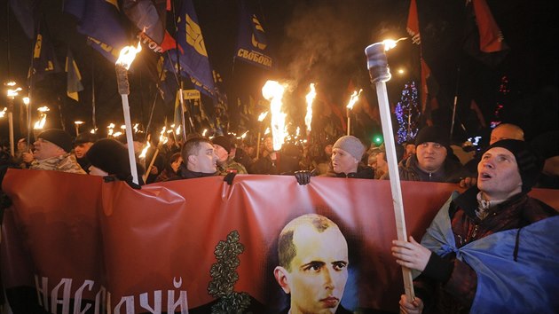 Kyjevem prošel průvod na počest Stepana Bandery. Účastníci kromě Banderova portrétu nesli i prapory Pravého sektoru a strany Svoboda (Ukrajina ,1. ledna 2014).