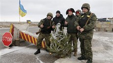 Ukrajintí vojáci a dobrovolníci pózují na kontrolním stanoviti u msta...