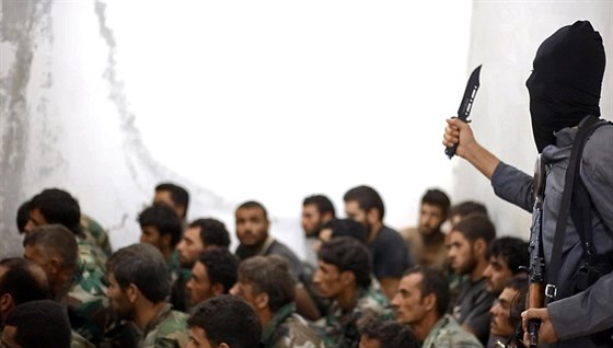 Rakká, Sýrie. Bojovník Islámského státu hrozí zajatým vojákům syrského...
