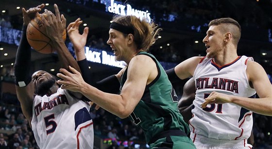 DeMarre Carroll (5) a Mike Muscala z Atlanty peislili pod koem Kellyho...