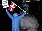 Demonstrant pózuje ped sochou Malé moské víly bhem protestu v Kodani (19....