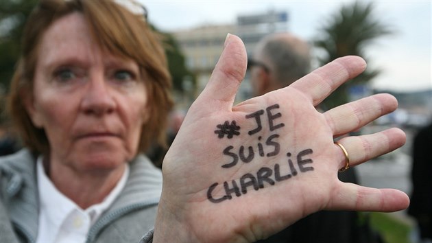 ena ukazuje ruku se vzkazem Je suis Charlie.