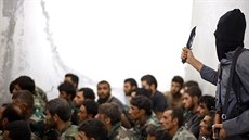 Rakká, Sýrie. Bojovník Islámského státu hrozí zajatým vojákm syrského...