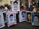 Píbuzní zmizelých student demonstrují s jejich portréty ped soudem v mst...