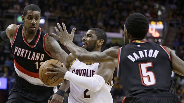 Kyrie Irving z Clevalandu se zkou prosadit pes dvojici LaMarcus Aldridge (vlevo) a Will Barton z Portlandu.