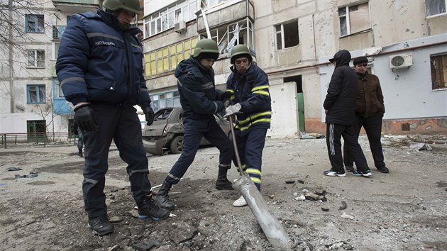 Ukrajinští záchranáři se snaží vyprostit část rakety typu Grad z místa sobotního útoku na obytnou čtvrť v jihovýhodním městě Mariupol (25. ledna 2015)