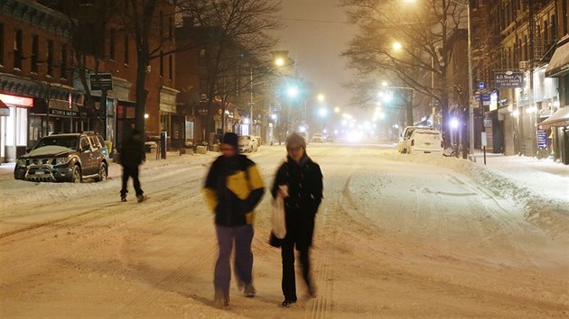 Obyvatelé Brooklynu jdou v úterý ráno středem zasněžené ulice kolem vchodu do metra u stanice Park Slope. (27. 1. 2015)