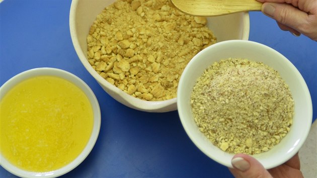 Jemně rozdrcené sušenky promíchejte s nastrouhanými mandlemi, přidejte tekuté máslo a vše dobře propracujte.
