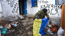 Povstalec drí ukrajinskou vlajku, kterou nael na kontrolním stanoviti u...