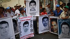 Píbuzní zmizelých student demonstrují s jejich portréty ped soudem v mst...