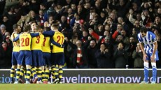KDE JE? Fotbalisté Arsenalu objímají Tomá�e Rosického (v kruhu druhý zprava),...